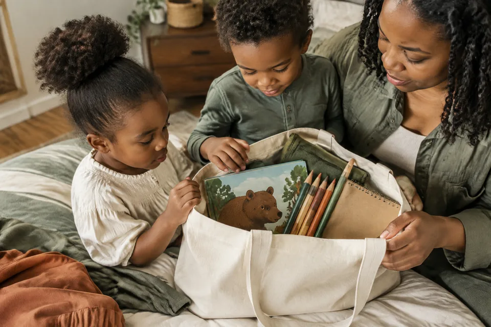 A compact screen-free travel kit fitting neatly inside a plain canvas tote, generous large drawing tools and picture-only book.
